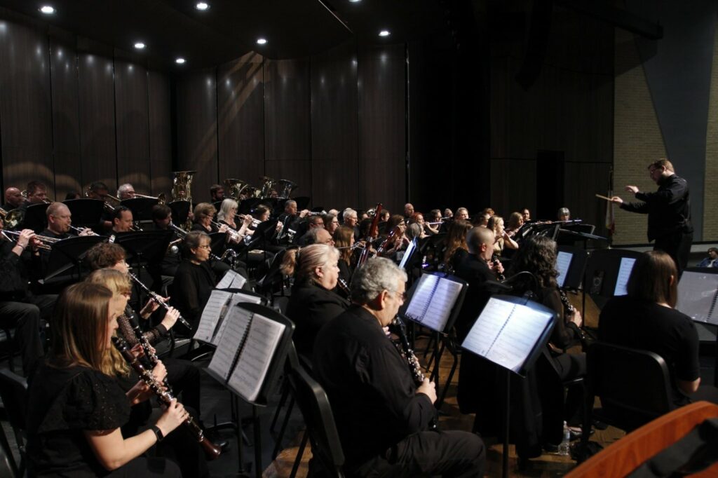 Montgomery Community Band performing a concert, view from behind performers